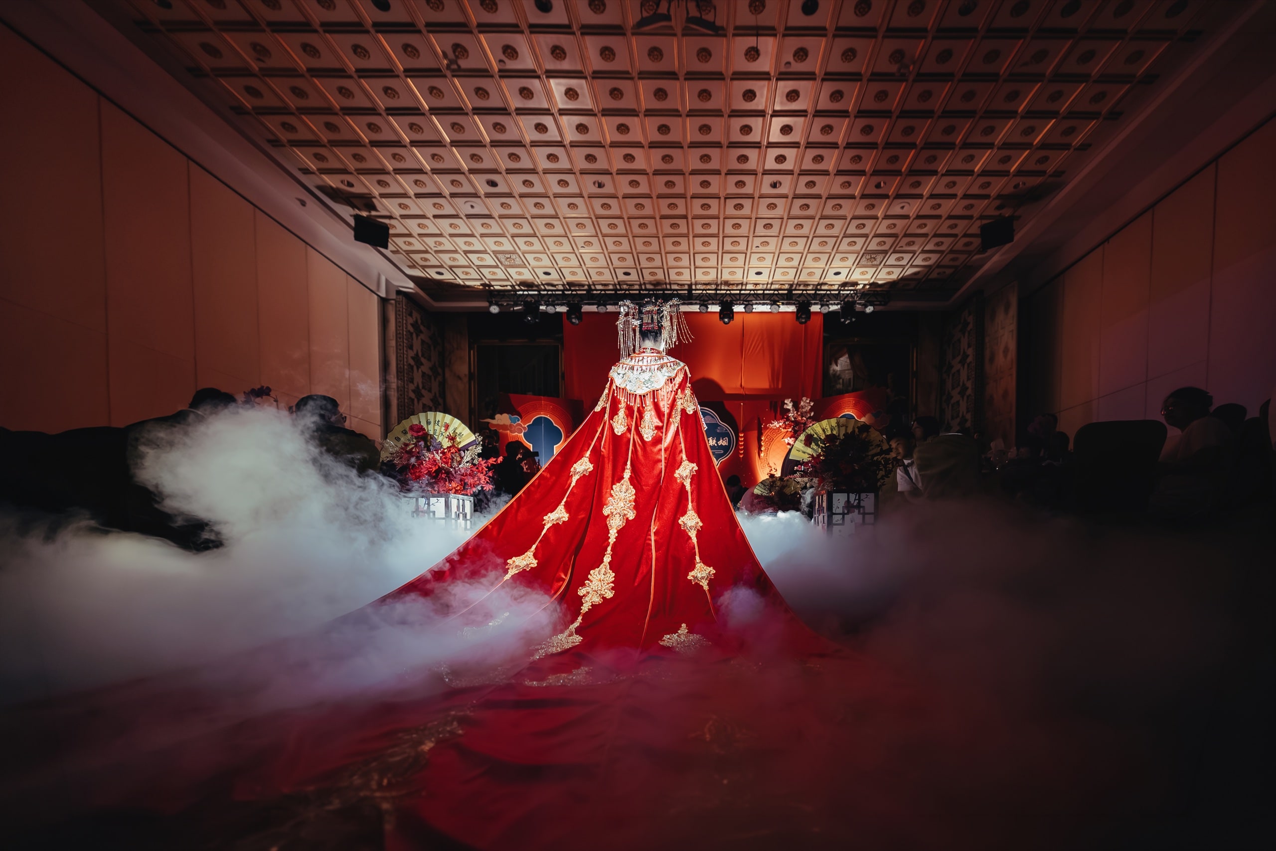 Bride in red 龙凤褂 walking down the aisle through dry-ice fog, banquet hall ceiling visible — Orchid Photo, GTA Chinese wedding