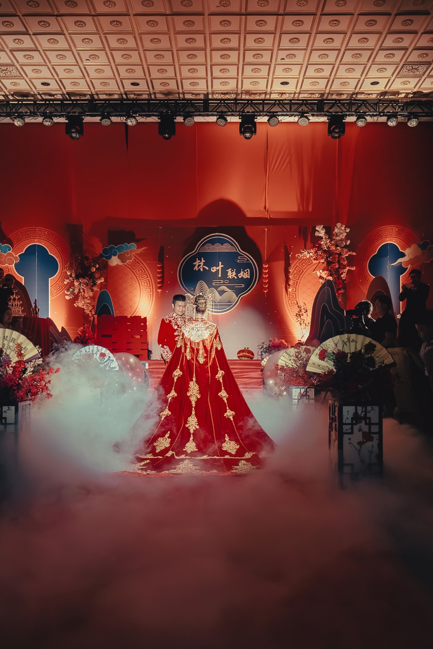 The couple on the red-lit ceremony stage