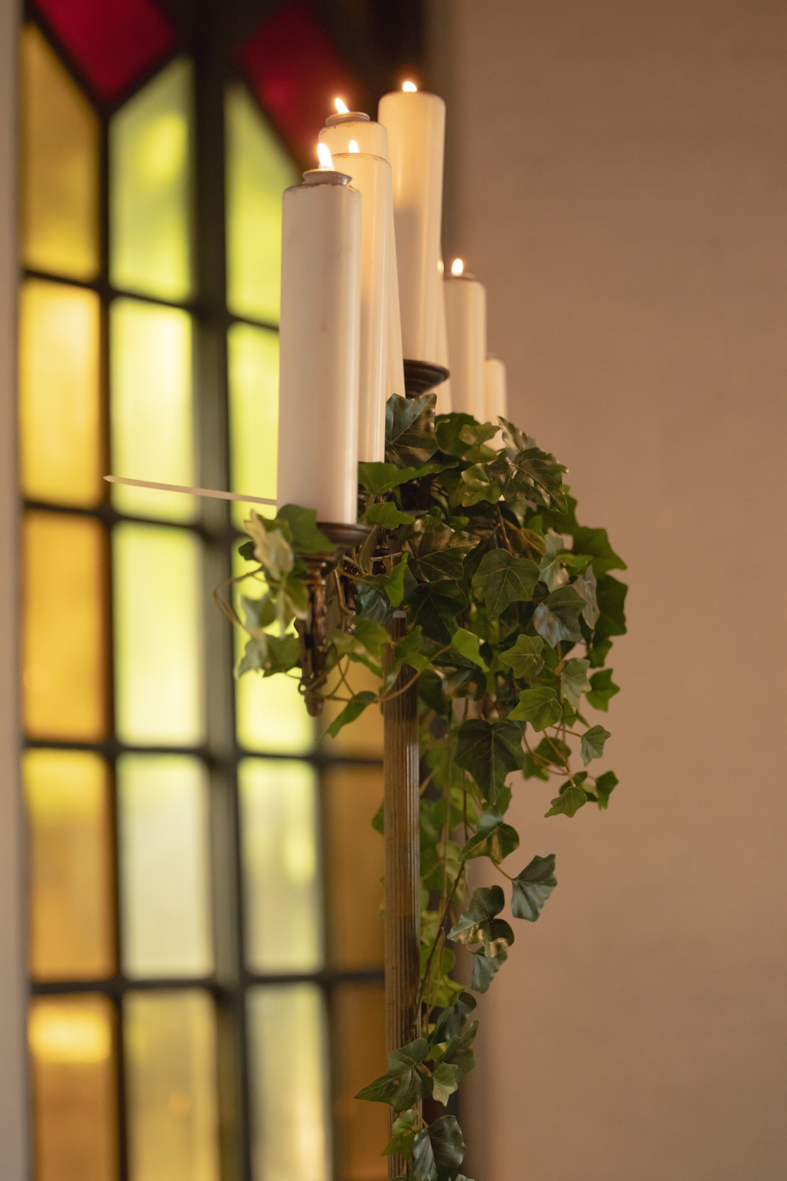 Stained-glass chapel window framed by white wedding florals at Old Mill Toronto