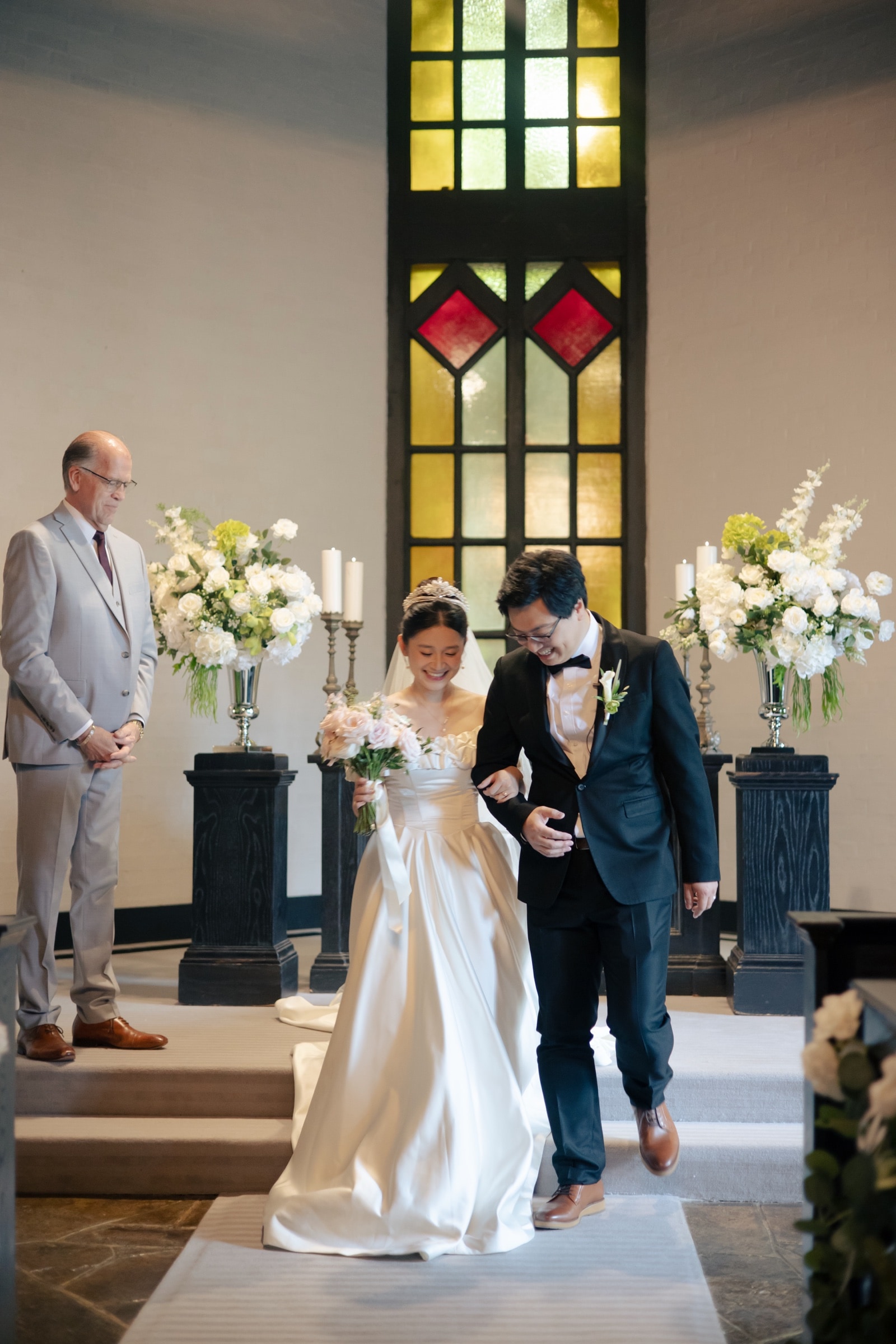 Guests celebrating as the newlyweds recess up the aisle