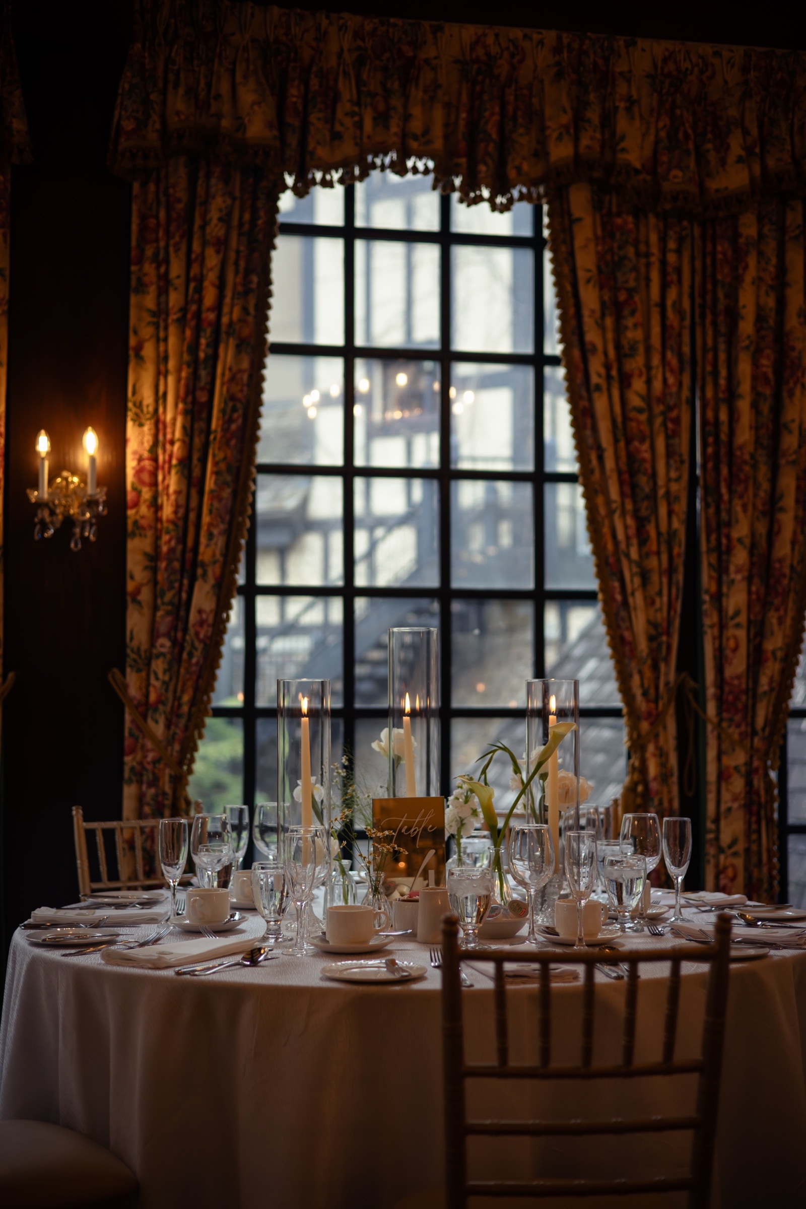 Reception florals framed by the leaded windows of the hall