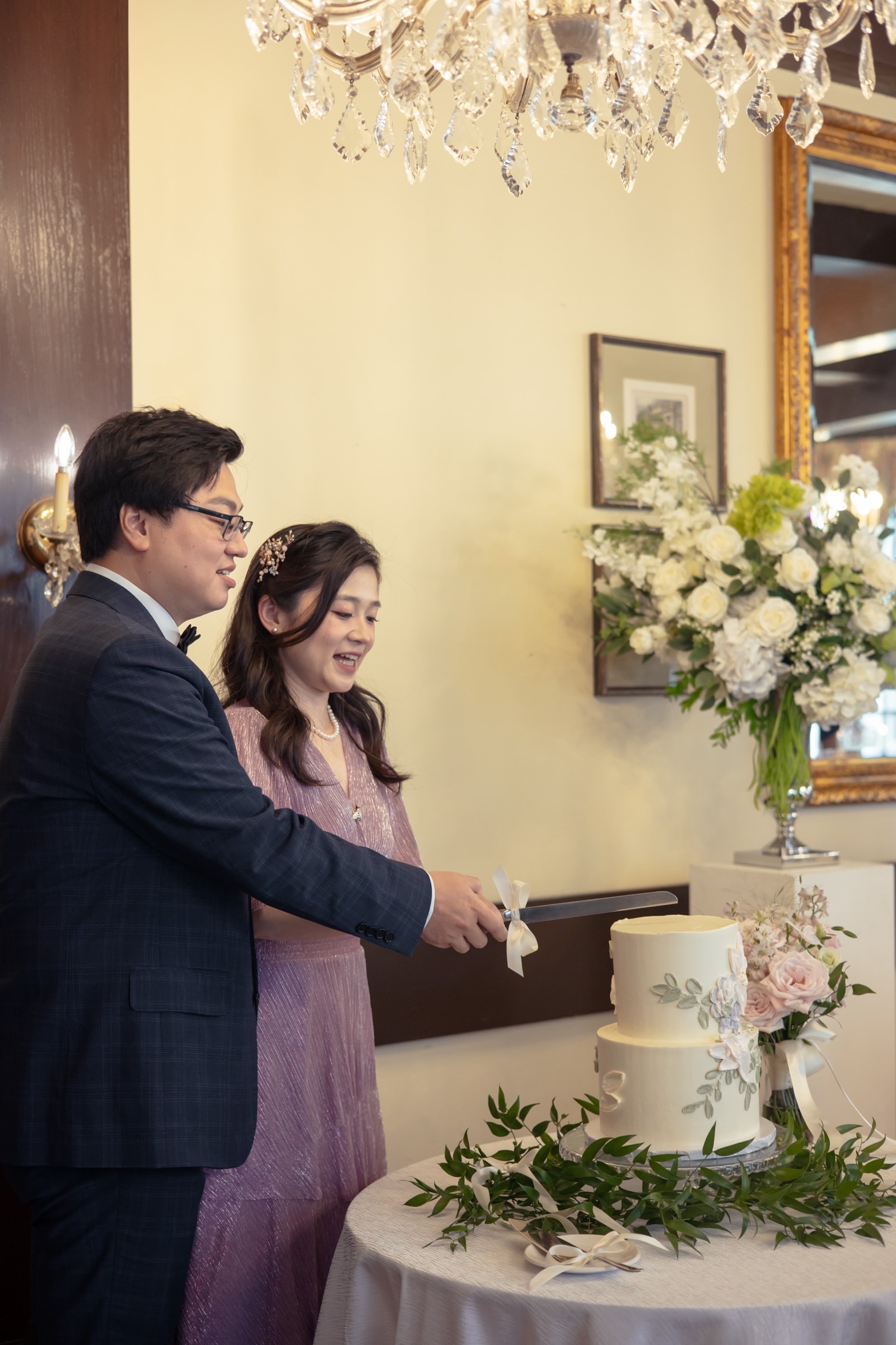 The couple cutting their floral wedding cake