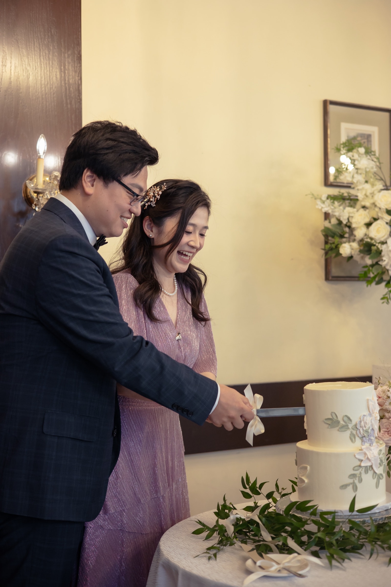 Close-up of the couple cutting the cake in the reception hall