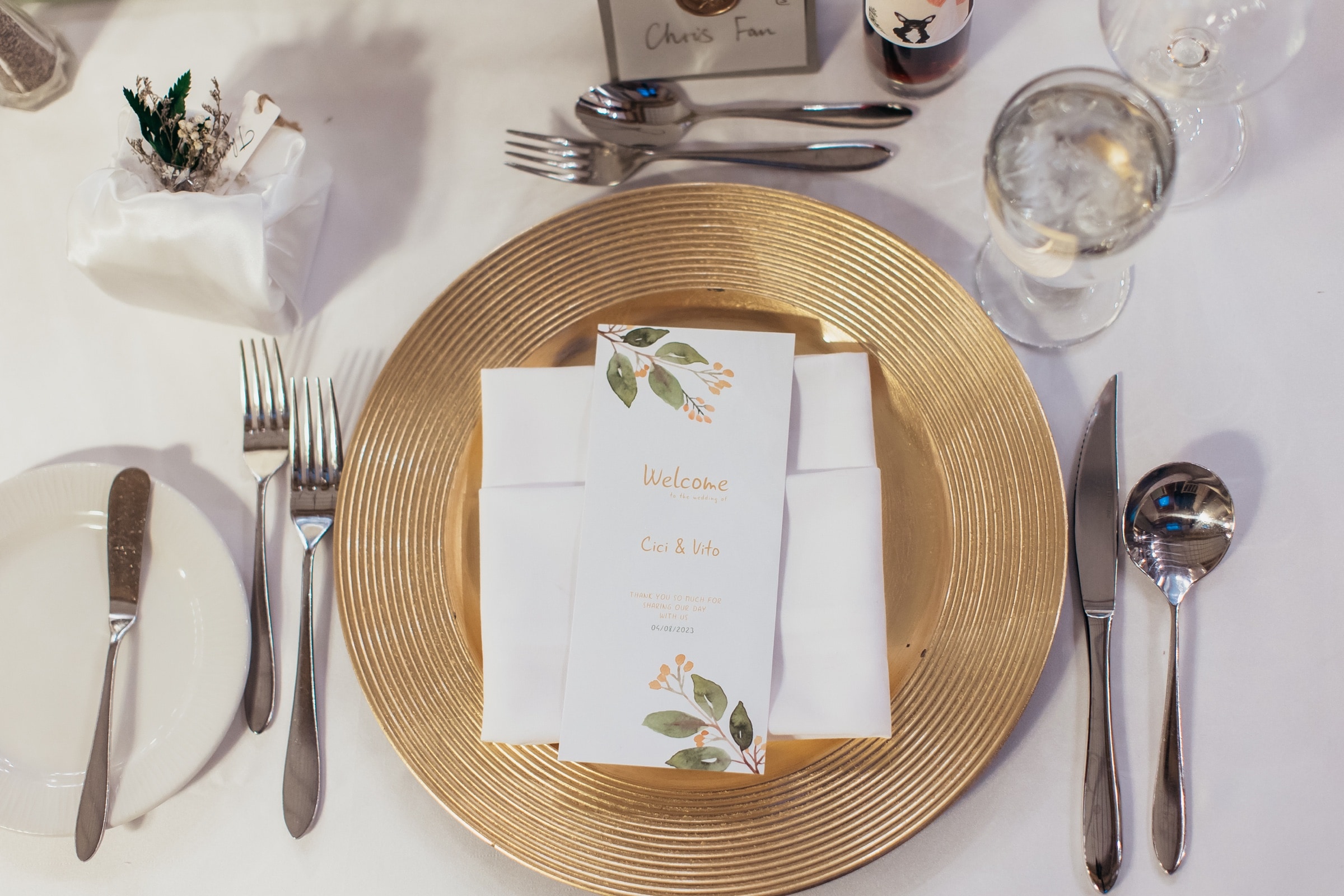 The reception place setting with a gold charger and menu