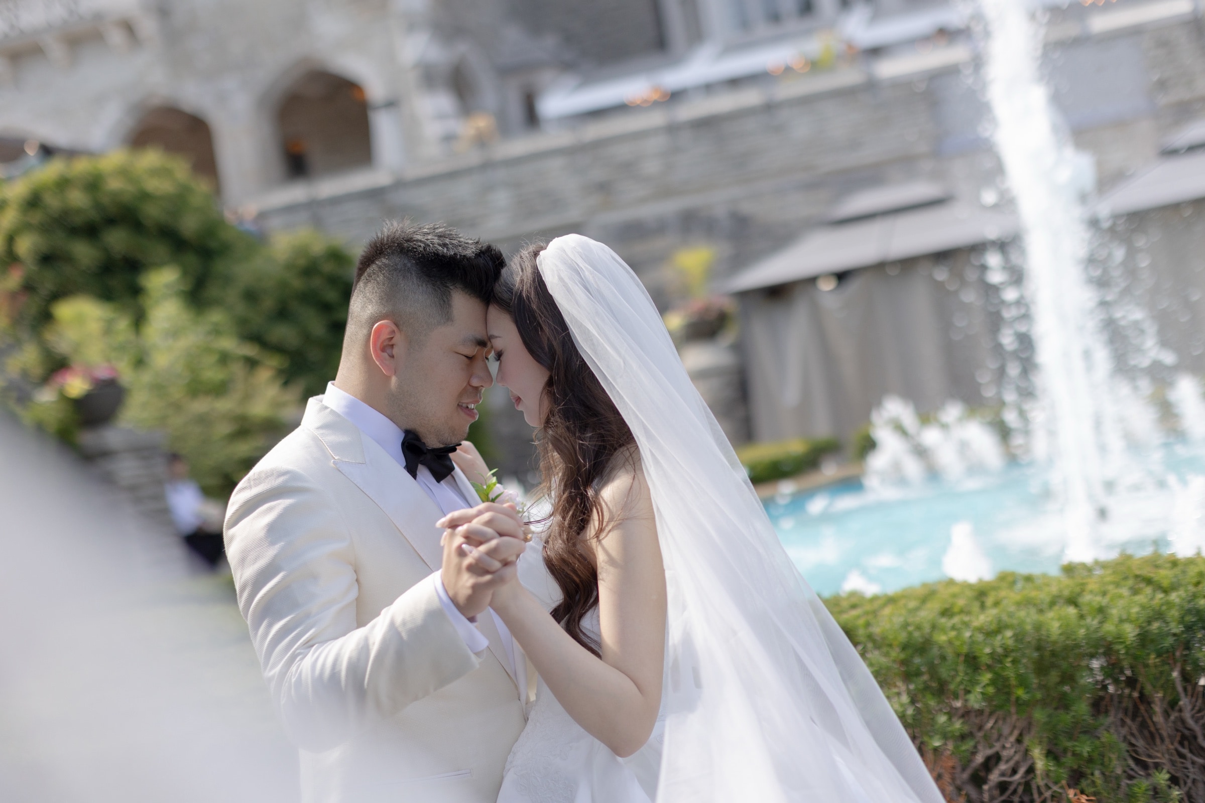 The couple forehead to forehead in a quiet portrait outside the estate