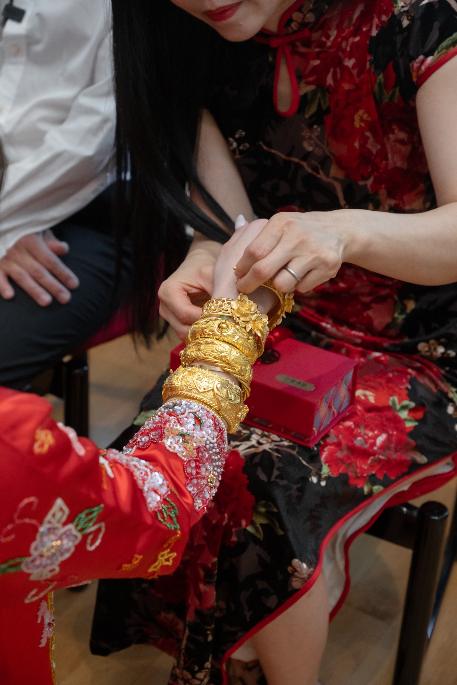 Heirloom gold bangles placed on the bride's wrist in the Chinese tradition