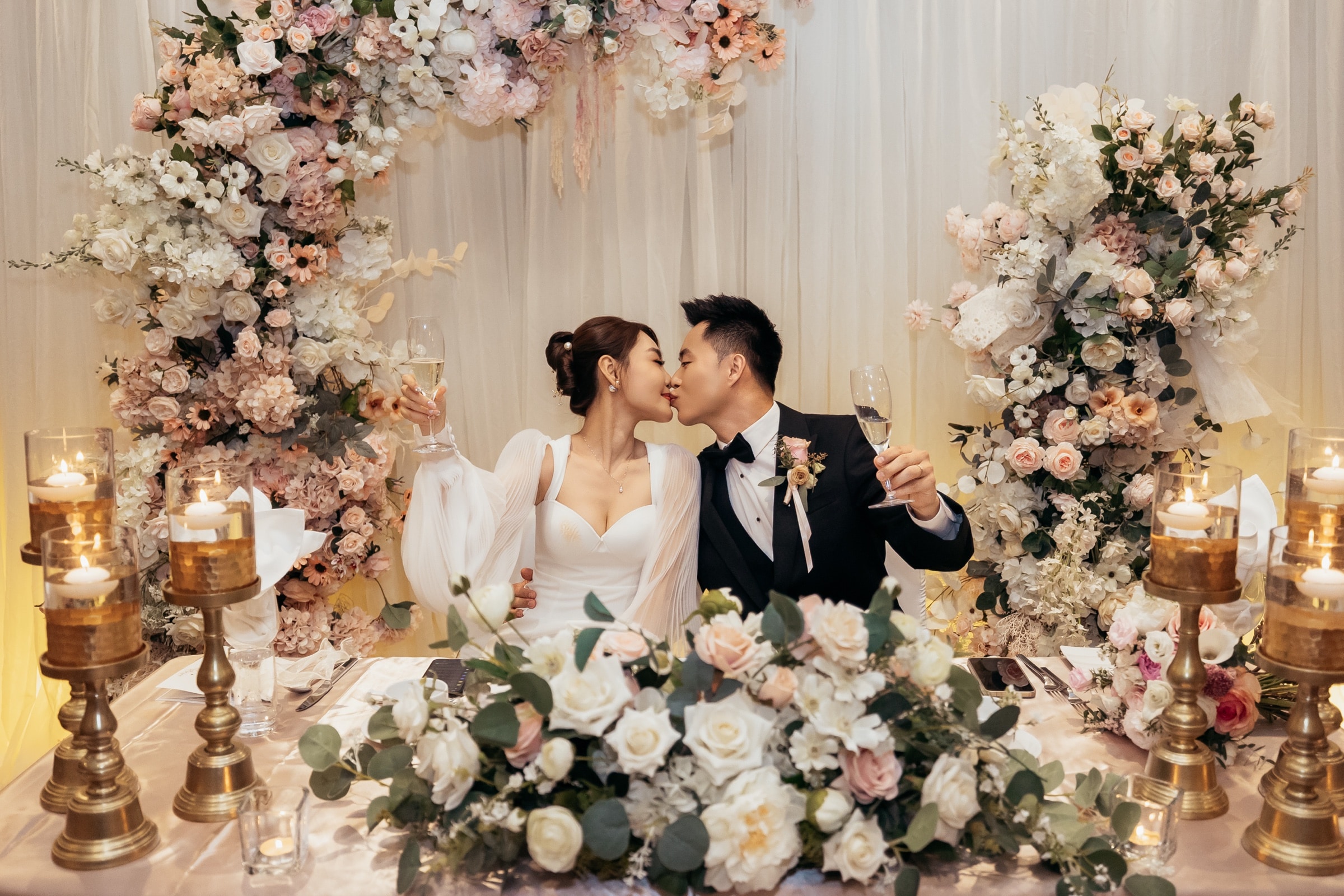 The couple kissing at the reception