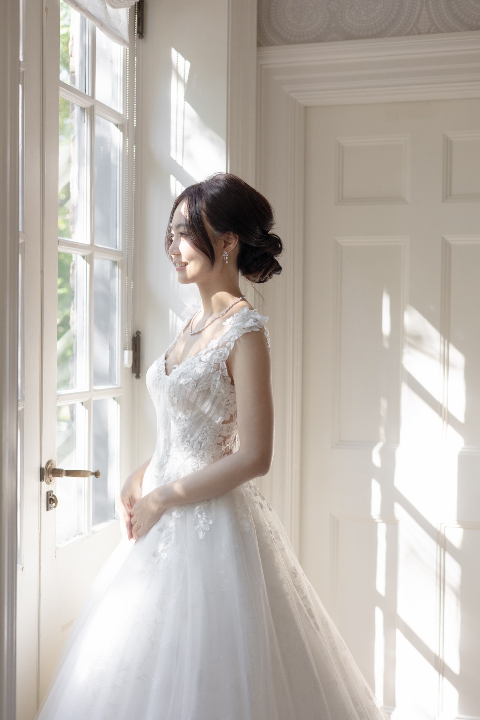 Bridal portrait by a tall window before the ceremony
