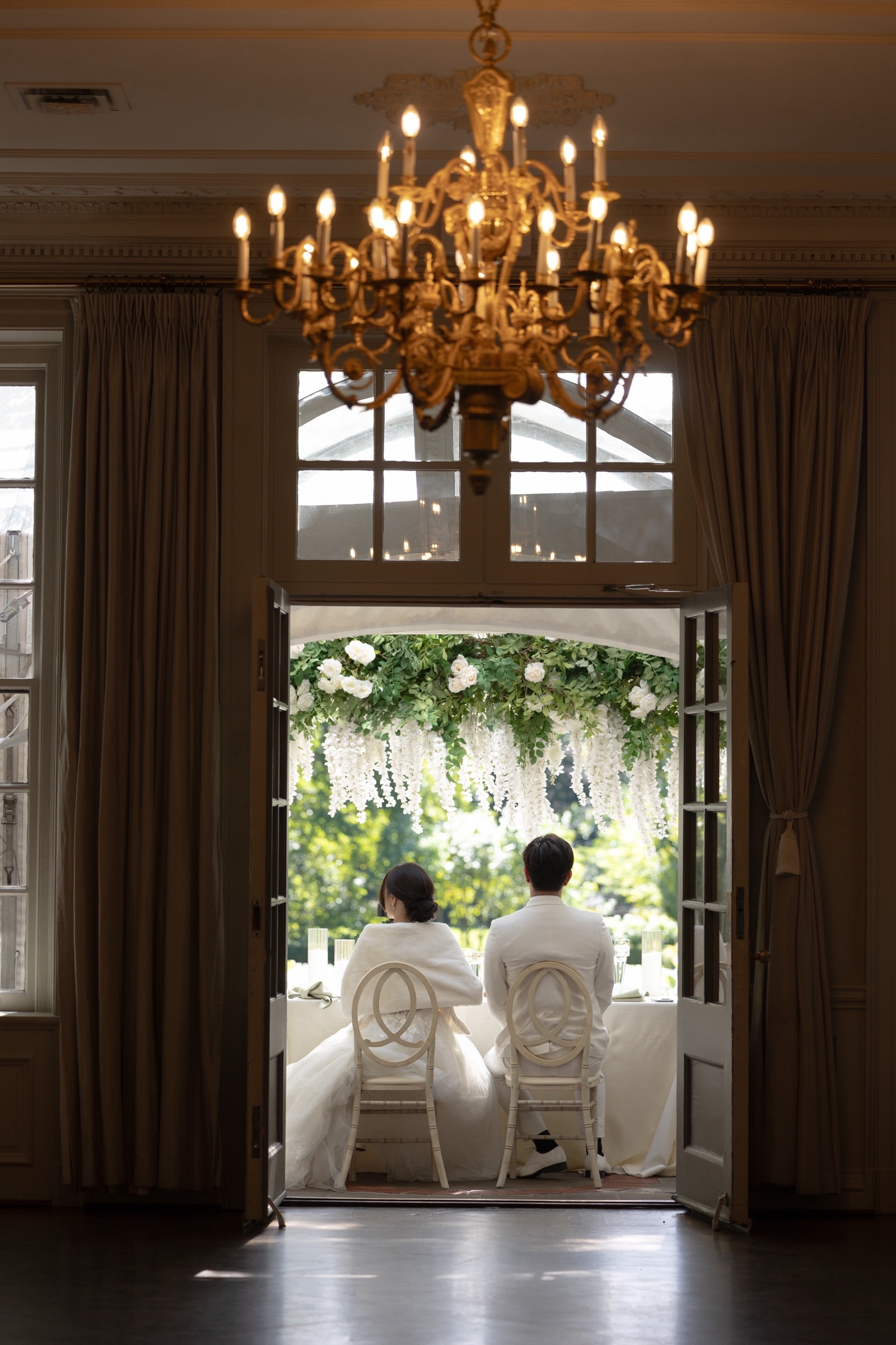 The white floral ceremony arch framed in a doorway