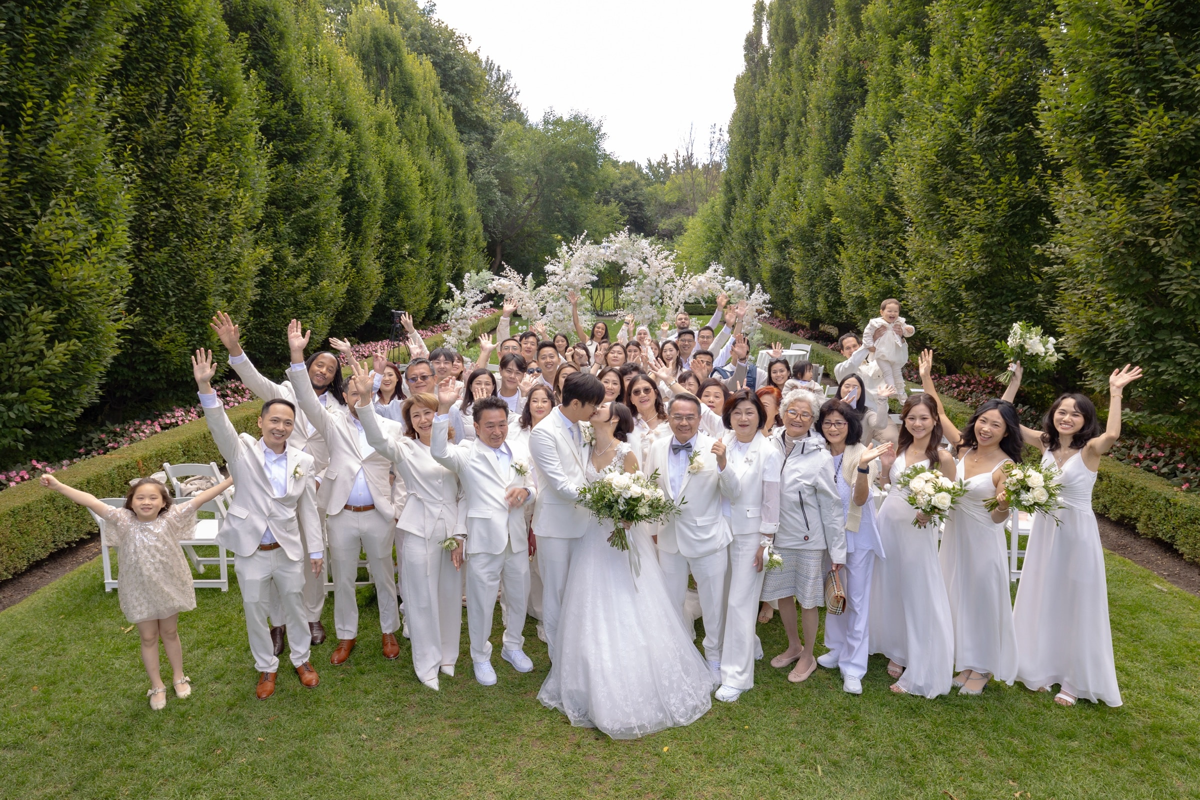 Guests in white celebrating together on the lawn
